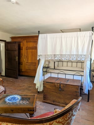 Camera Gigante di Fiandra, Poggio al Coniglio Suvereto: letto a baldacchino con tendaggi, pavimento in cotto e cassapanca