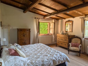 Camera Fata di Marburgo, villa Poggio al Coniglio a Suvereto: letto matrimoniale, travi a vista e arredi d’epoca con finestra sul giardino