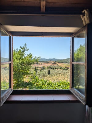 Finestra aperta con vista su vigneti, oliveti e cipressi delle colline toscane — Poggio al Coniglio, villa a Suvereto con camere in affitto